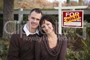 Happy Couple in Front of Sold Real Estate Sign