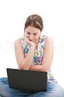 Beautiful young woman sitting on floor with a laptop, isolated o