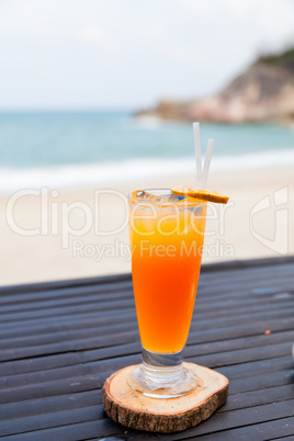 Orange juice in glass with ice, straw and fruit slice