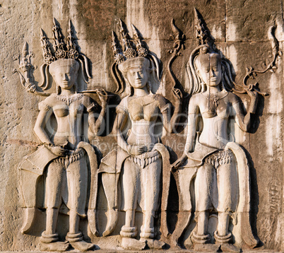 Three dancing apsara on the wall in Angkor Wat