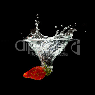 strawberry splashing in water over black background