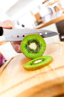 Woman's hands cutting kiwi