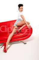 Leggy Retro Model On Red Leather Sofa