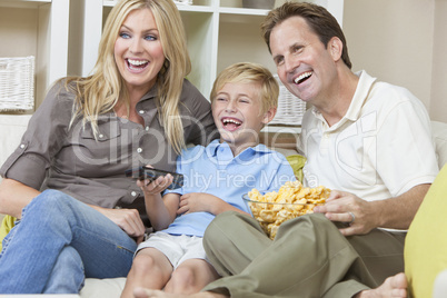Happy Family Sitting on Sofa Laughing Watching Television