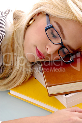 close view of female sleeping on books
