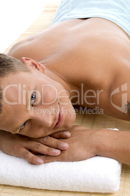 young male lying on mat ready to take spa treatment