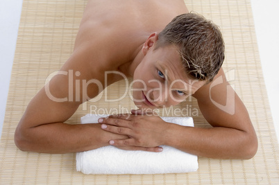 young male lying on mat ready to take spa treatment