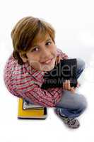 side view of boy sitting on pile of books