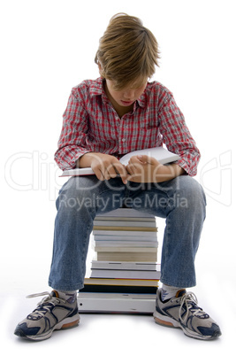 front view of boy sitting on books on white background