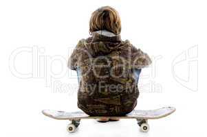 back pose of boy sitting on skate