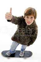 top view of boy riding skate and showing thumbs up