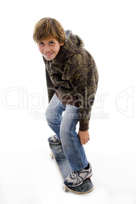 side pose of boy riding skateboard