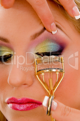 close view of model curling her eyelashes