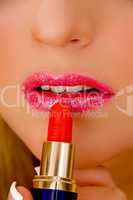 close view of model applying lipstick