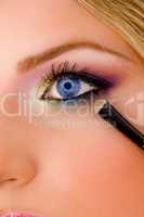close view of young model putting eyeliner