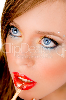 close up of beautiful woman applying lipstick