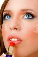 close view of female applying lipstick
