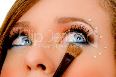 close view of young woman putting eyeliner
