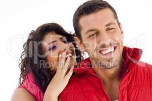 cheerful young couple whispering to each other