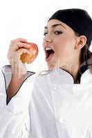 young beautiful chef eating apple
