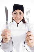 young chef holding metal cutlery