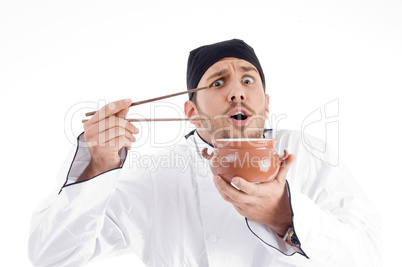 surprised young chef posing with bowl and chopstick