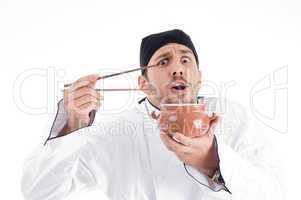 surprised young chef posing with bowl and chopstick