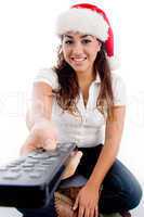 woman wearing christmas hat and showing remote
