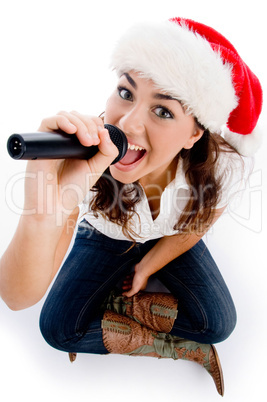 model holding karaoke and wearing christmas hat