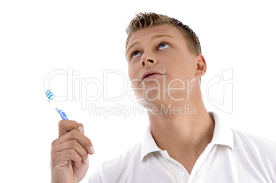 healthy male posing with toothbrush and looking upwards
