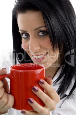 front view of smiling doctor holding mug on white background