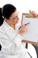 side view of female doctor indicating writing pad on white background