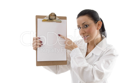 portrait of female doctor pointing writing pad on white background