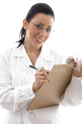 front view of smiling doctor with writing pad on white background