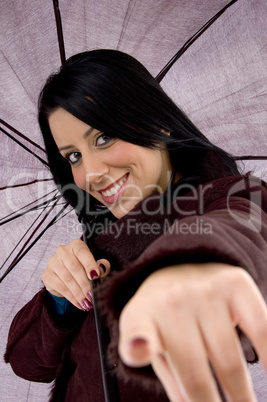 front view of pointing woman holding umbrella on white background