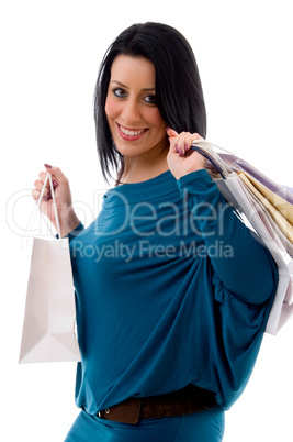 side pose of smiling model with carry bags on white background