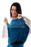 side pose of smiling model with carry bags on white background