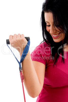 half-length view of female exercising with rope on white background