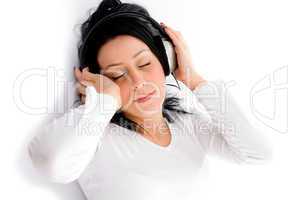 top view of laying woman enjoying music against white background