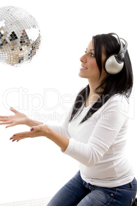 side view of smiling female playing with disco mirror ball