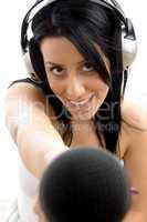 top view of smiling female posing with headphone and microphone