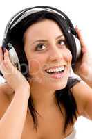 front view of smiling female enjoying music against white background