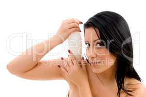 portrait of female holding lotion bottle against white background
