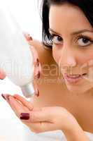 close up of woman taking lotion in hand on an isolated white background