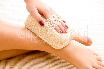 close view of woman scrubbing her leg against white background