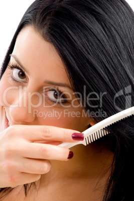 portrait of adult woman combing her hair on an isolated white background