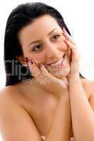 portrait of smiling female touching her face on an isolated white background