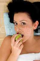 high angle view of smiling woman eating apple on an isolated white background