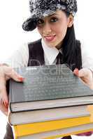 student in cap holding stack of books