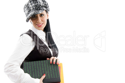 female student wearing cap holding books